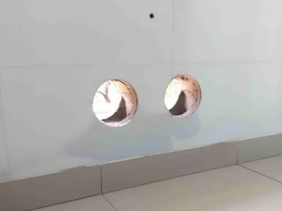 Dois furos circulares acabados em parede de concreto para passagem de tubulação
