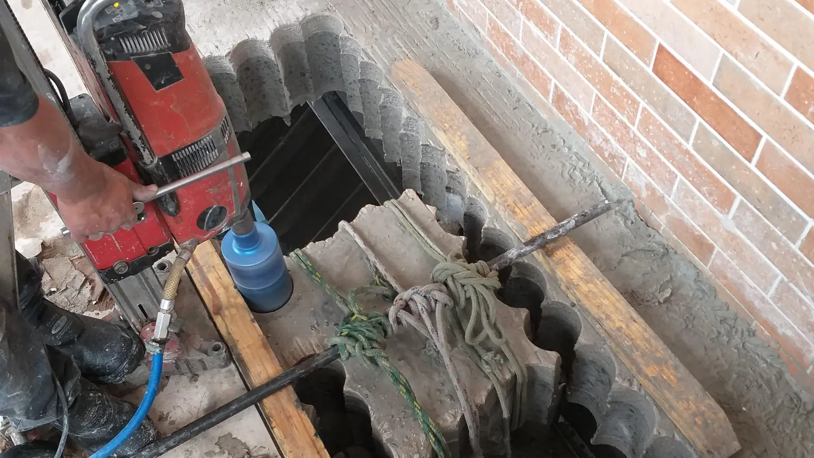 Perfuratriz diamantada executando sequência de furos em concreto armado em obra
